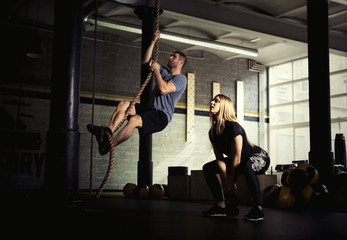 Obraz na płótnie Canvas Man and woman doing exercises in gym