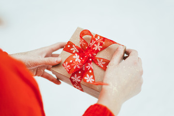 Girl holds a Christmas gift in her hands