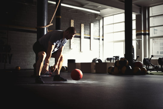 Man training with heavy medicine ball in gym