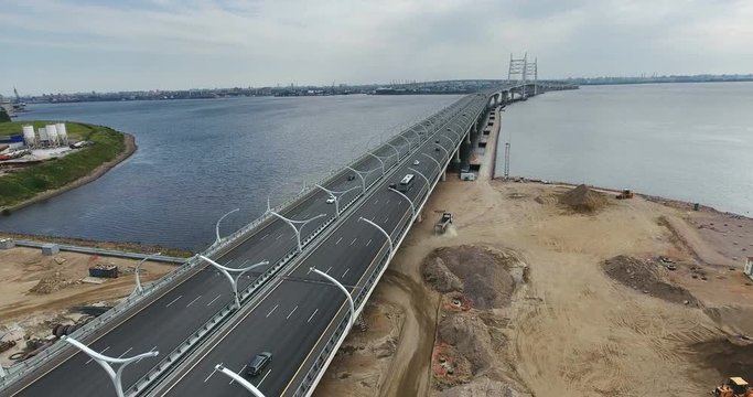 Vehicles driving new part of Western High Speed Diameter highway from Vasilyevsky Island to city center across Korabelny fairway. Aerial view. Gulf of Finland. Saint-Petersburg, Russia
