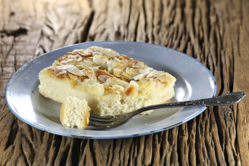 Traditional North German Butterkuchen (butter cake) on old enamel plate. Butterkuchen is a favorite element of Westphalian and North German coffee tables.