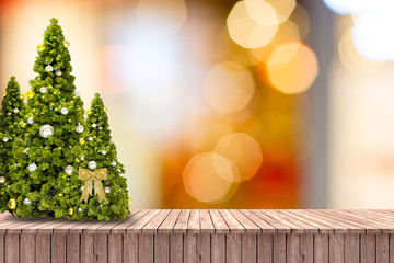 Christmas trees on wooden floor and blurred background.