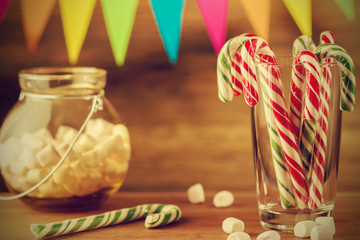 Sweets for Christmas. Greeting card. Candy canes and marshmallows. Retro style photo.