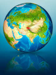 Tajikistan on Earth on reflective surface