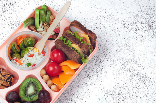 Open lunch box with healthy lunch on grey background with copy space