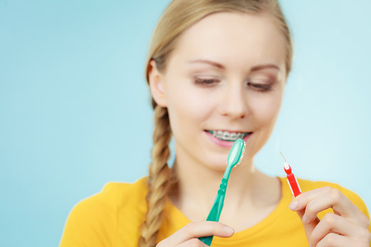 Girl with teeth braces using interdental and traditional brush