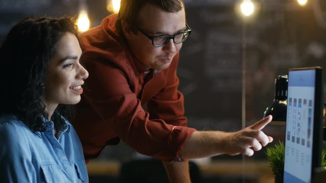 Beautiful Female Mobile Gaming Application Developer Talks With Her Male Colleague, They Discuss Creative Design. Stylishly Lit Office. RED EPIC-W 8K Camera.
