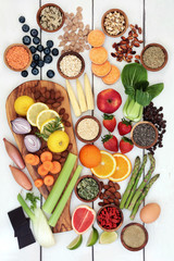 Healthy diet food for weight loss with fresh fruit, vegetables, nuts, seeds, grains, cereals and dairy with herbs used as an appetite suppressant. Top view on rustic background.
