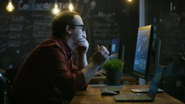 Stressed Financier Hits the Table with His Fist in Frustration and Covers His Face in Hands. He's Working on a Personal Computer with Statistics Showing on the Screen. RED EPIC-W 8K Camera.