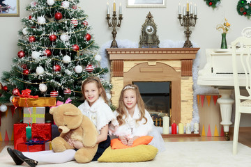 Obraz na płótnie Canvas Girls twins with gifts e Christmas tree.