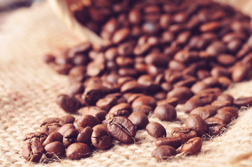 Coffee beans spilled from the basket on a burlap