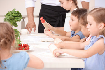 Obraz na płótnie Canvas Cute children in kitchen during cooking classes