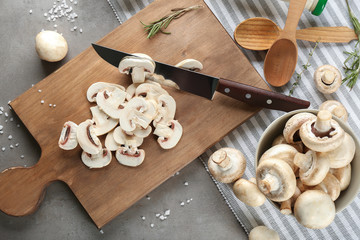 Fresh sliced champignon mushrooms on wooden board