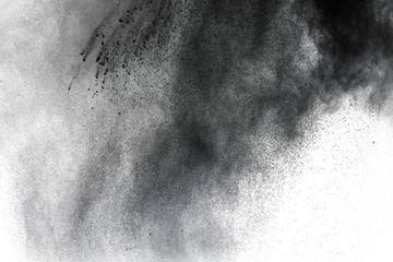 Black powder explosion against white background.The particles of charcoal splatted on white...