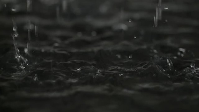 Water drop falling to liquid surface Full HD slow-motion video nature background. Clean rain waterdrop drips and splashing. Gray dark abstract waves and bubbles