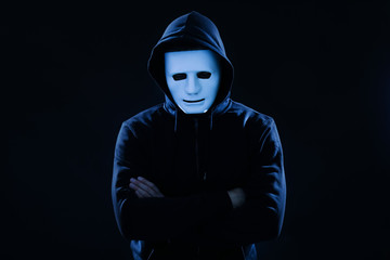 Hacker in mask on dark background