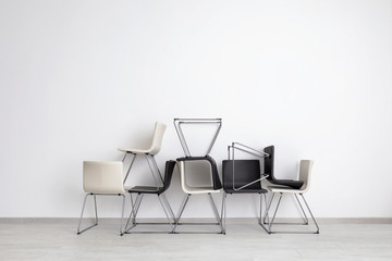 Composition with modern chairs near light wall