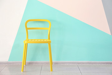 Comfortable chair near color wall