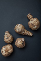 A bunch of Jerusalem artichokes or sunbeams isolated on a black background