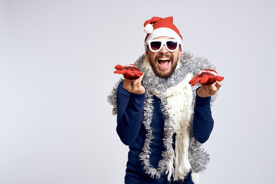 light background, free space for copy, party, man holding gloves, tinsel, new year