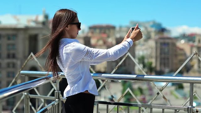 Businesswoman records videos and makes photos on his smartphone. Beautiful girl with red cell phone