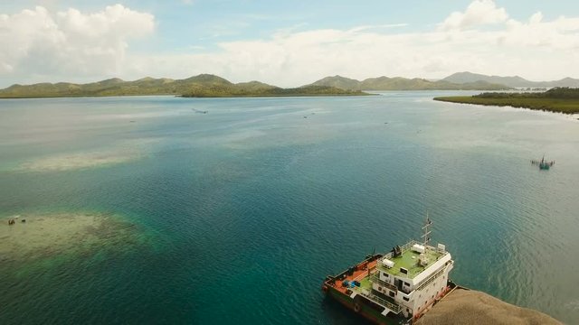 Cargo and passenger port with barges and cargo ships on tropical island. Aerial view:passenger ferry terminal Dapa city .Ferries for transport vehicles and passengers in the port. Philippines, Siargao