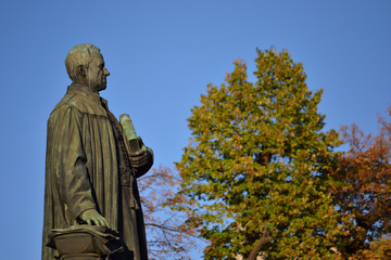 Bronze statue of a scholar in an autumn landscape