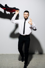 Happy businessman man okay gesture with fly jacket sign on gray background
