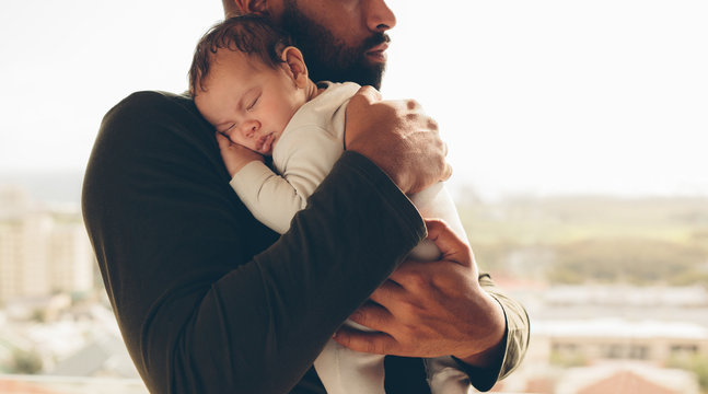 Newborn baby boy in his father's arms