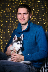 Obraz premium man in a Christmas atmosphere with a Husky puppy