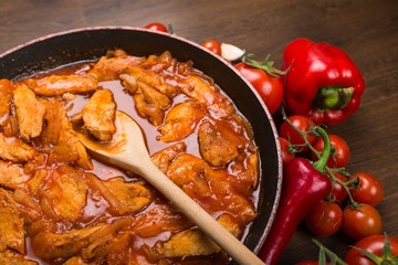 Stew meat on the frying pan with peppers and tomatoes