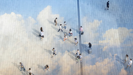 top aerial view people walk on the pedestrian city street walkway on pavement concrete reflect cloud and blue sky.