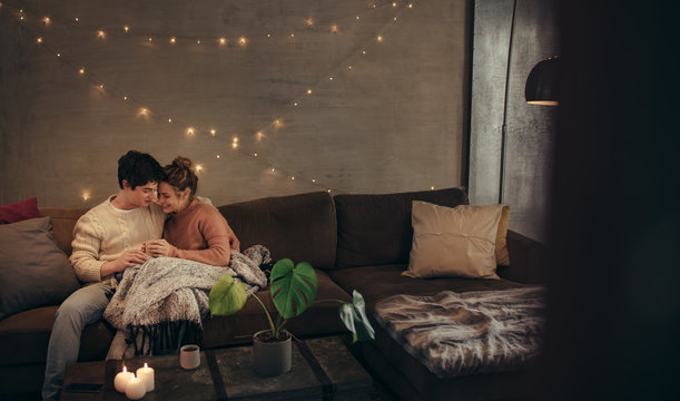 Couple relaxing on couch in hygge house