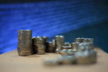coin chart pile and blue binary coding computer screen selective focus