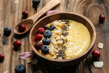 Mango Smoothie breakfast bowl with chia seeds berries coconut and granola ,selective focus