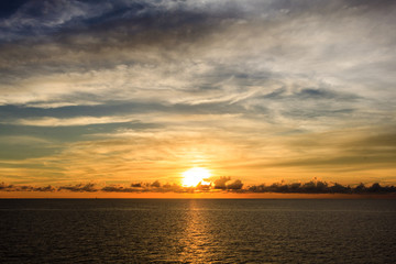 Blue sea and sky with sun red light reflected in the middle sea