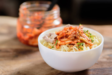 Korean food,instant noodle with kimchi cabbage in a bowl on wooden background