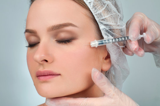 Woman is getting filler injection in cheeks. Anti-aging treatment and face lift. Cosmetic Treatment and Plastic Surgery
