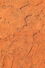 Fototapeta premium Vertical orange adobe clay rough background texture