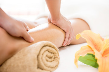 Obraz na płótnie Canvas Therapist giving relaxing Thai oil leg massage treatment to a woman in spa
