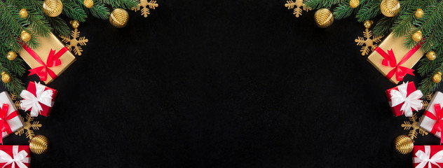 Christmas gift boxes and shiny golden decorating ornaments on blackboard background