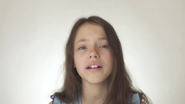 Beautiful sad teenage girl emotionally expresses pain and resentment close-up on white background stock footage video