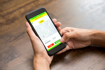 Woman hand touching smartphone screen confirming taxi booking online via application