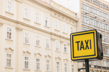 Information sign of a taxi on the background of houses in a European city.