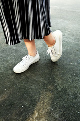 White Sneakers Shoes. Woman is Legs in White Sneaker and Pants on the Concrete Street Background Great for Any Use.