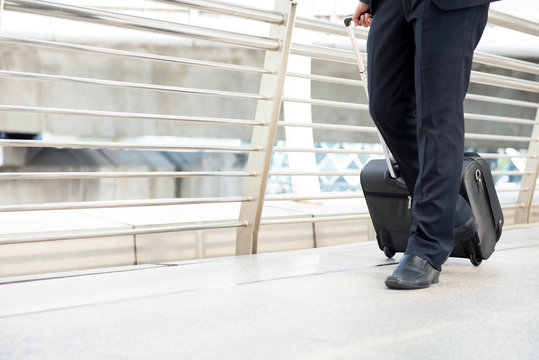 Businessman pulling luggage at airport terminal