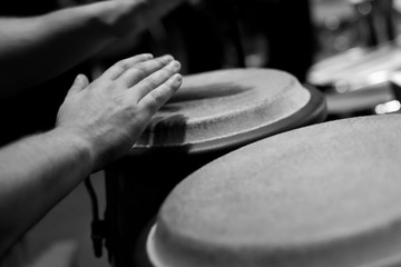  Hands of a musician playing on bongs closeup in black and white tones