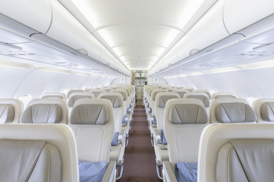 Interior of empty ready to fly airliner cabin with rows of seats.