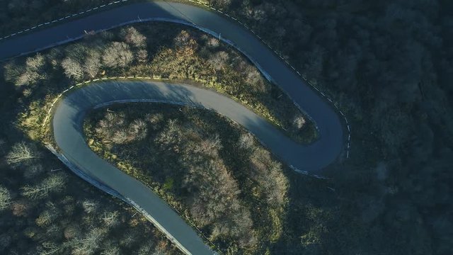 The aero shot of wilderness and local logistics linking. Panorama in motion over windy pathway. The helicopter flight and turning, wild curvy switchback with no cars, spring daily area, point of view