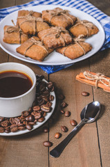 Black coffee in a white cup on a blue napkin and homemade cookies.